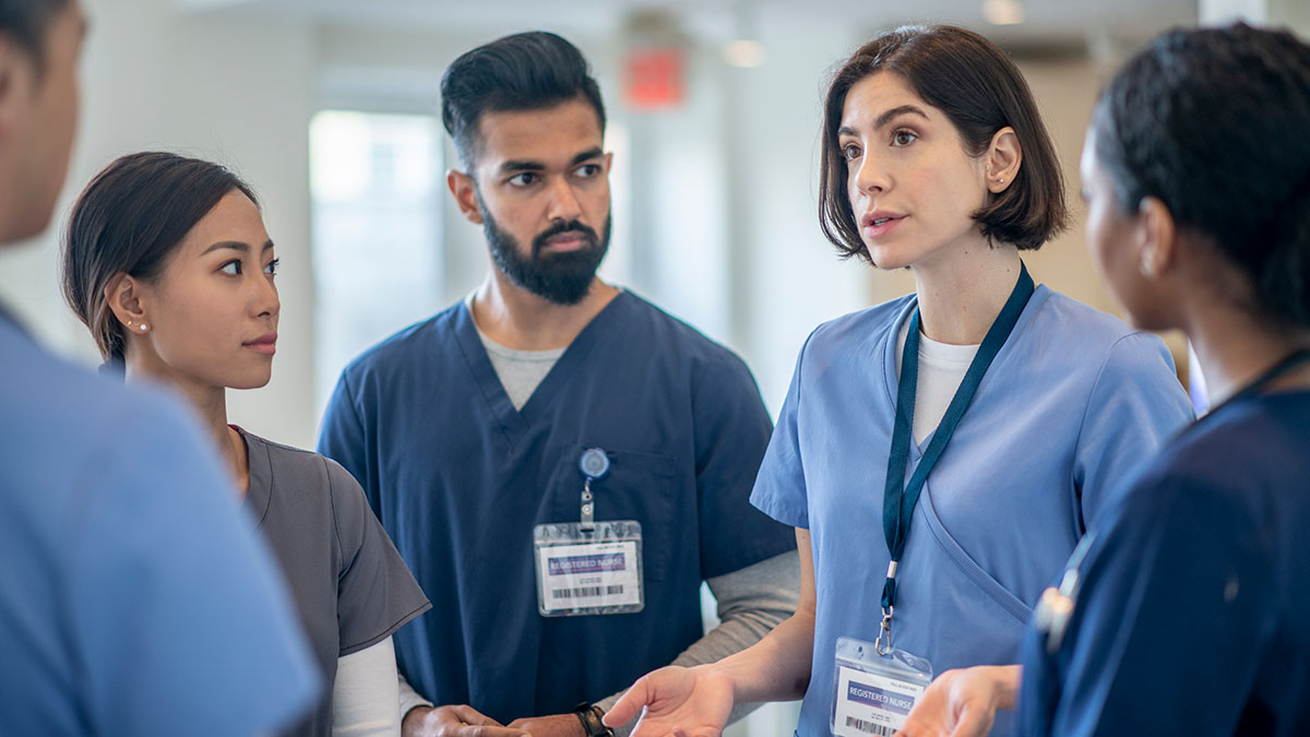 A group of medical providers engaged in conversation.